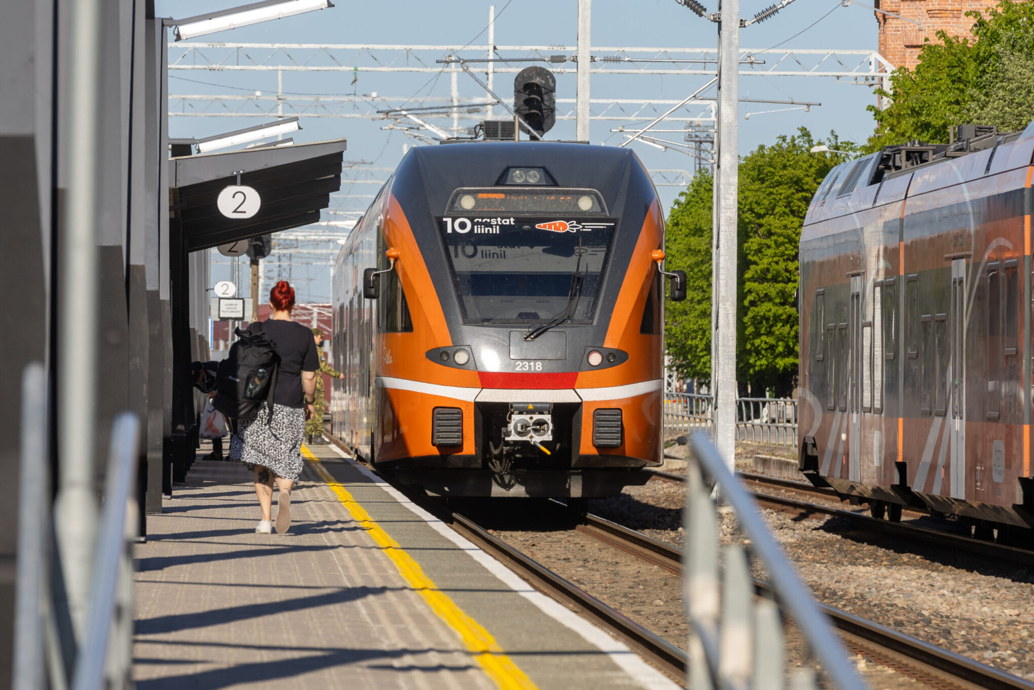 Woman walks toward an Elron train